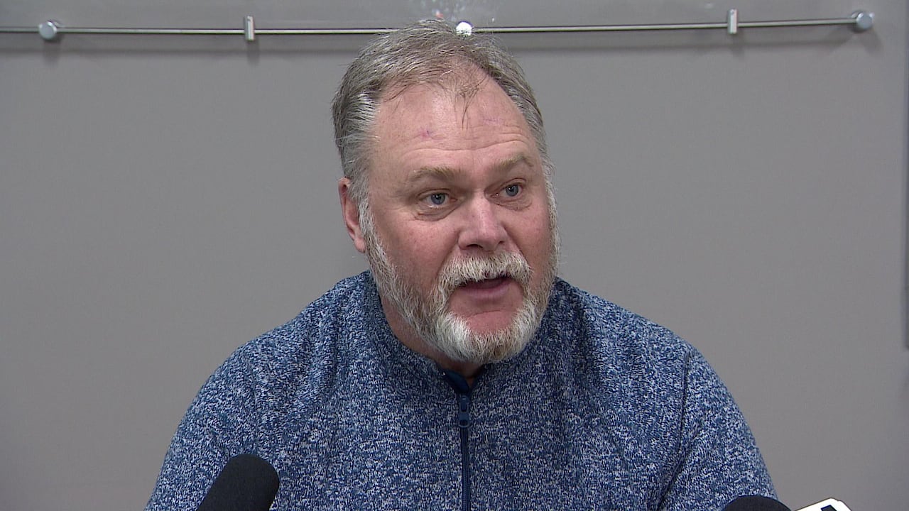 Tom Sargeant is visible from chest to head, wearing a sweater.