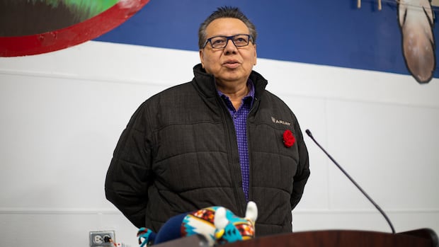 A man stands talking at a podium.