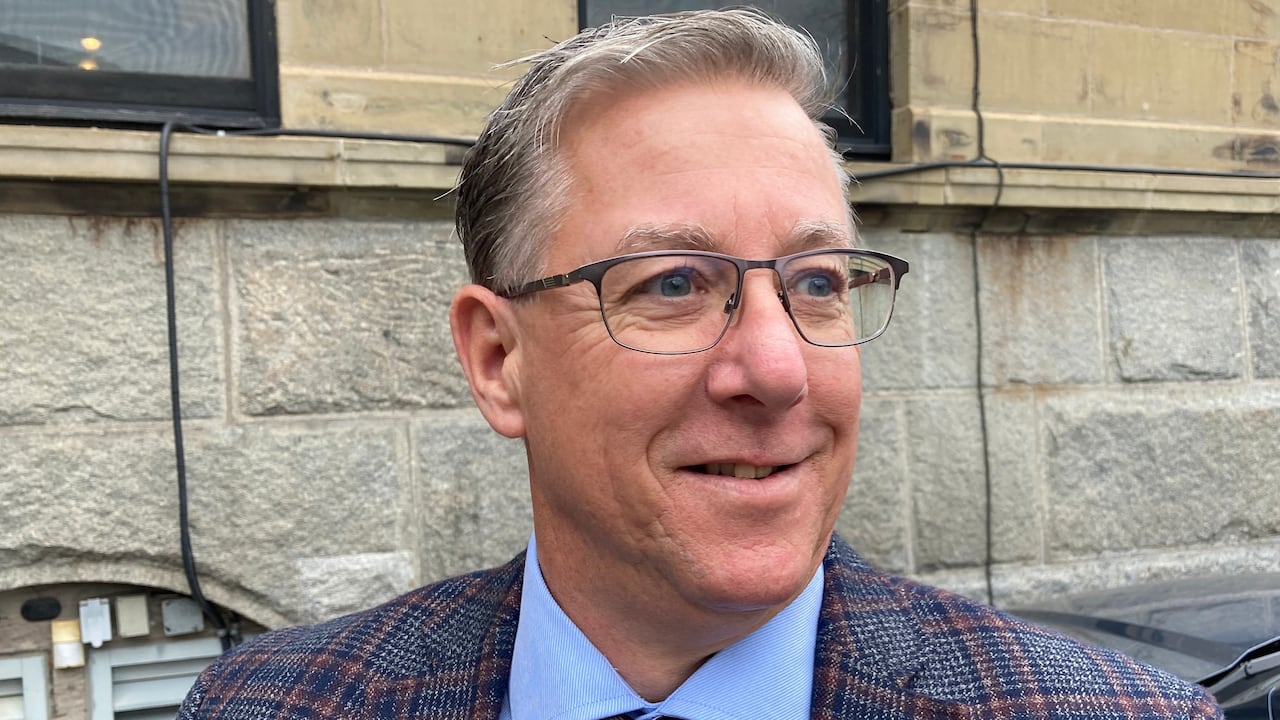 A man wearing glasses in a suit. 