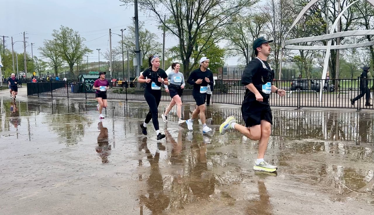 People running in the rain on cement.