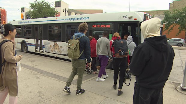 A crowd of people are about to board a bus.