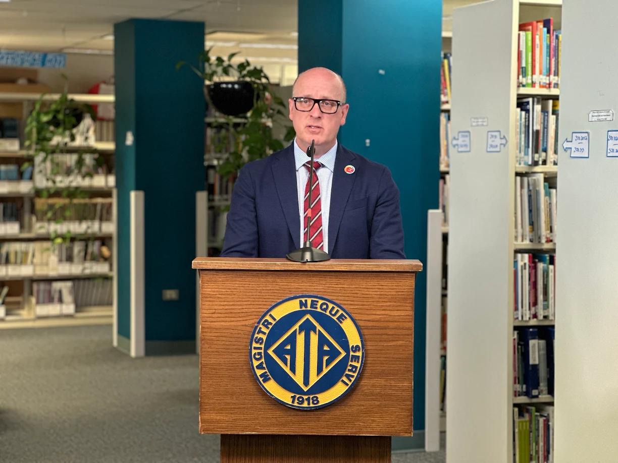 Alberta Teachers' Association might take the government to court. Here's what we know; A person behind a podium\.