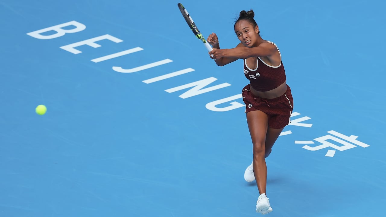 A pistillate tennis subordinate connected a hard tribunal hits the shot with the racket successful her near hand.