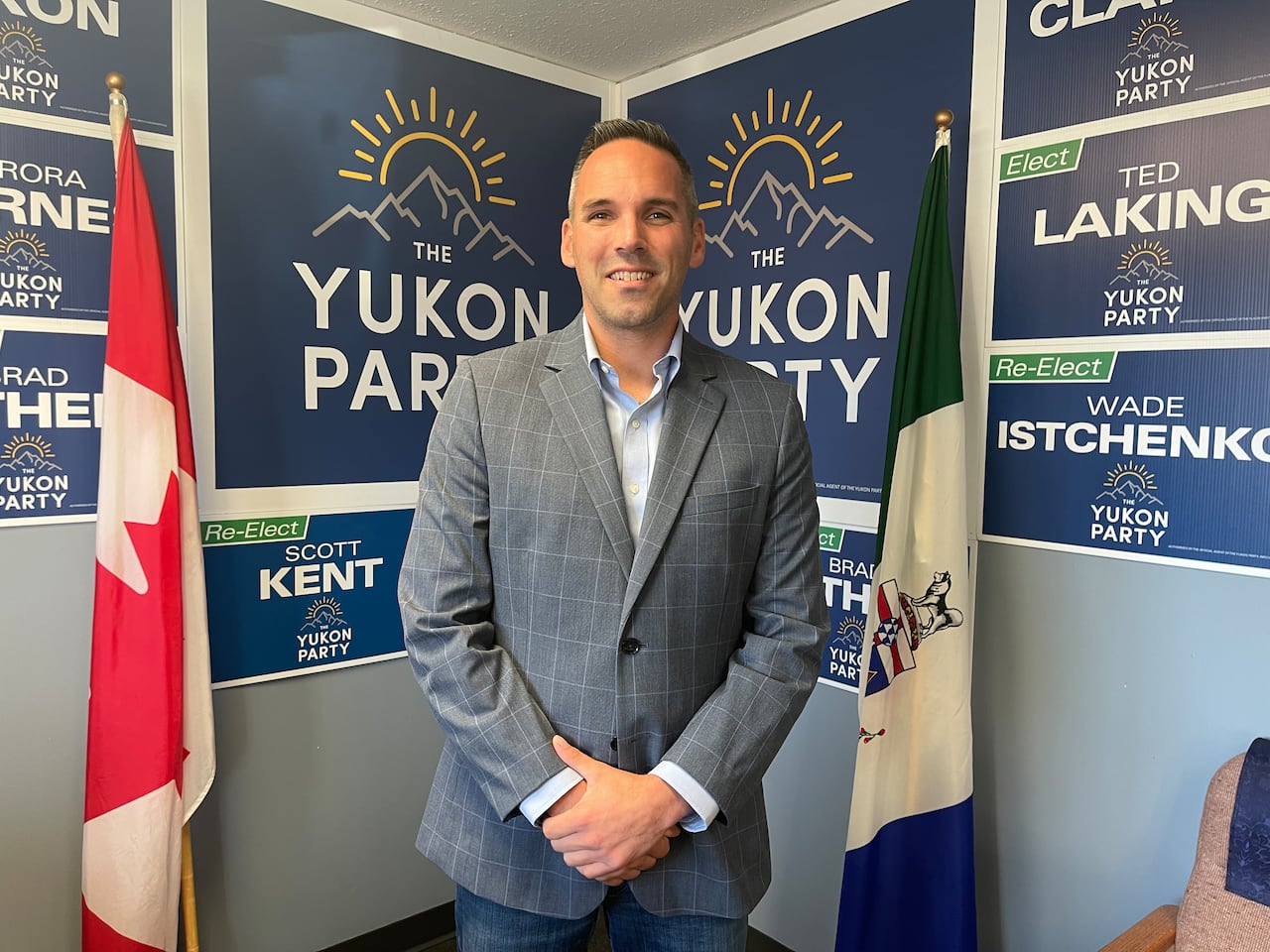 Currie Dixon is leader of the Yukon Party. A man stands in a room in front of some Yukon Party election signs.
