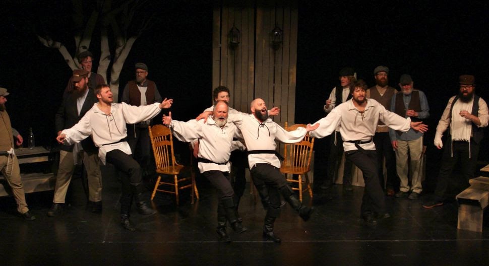Men in white shirts dancing on stage.