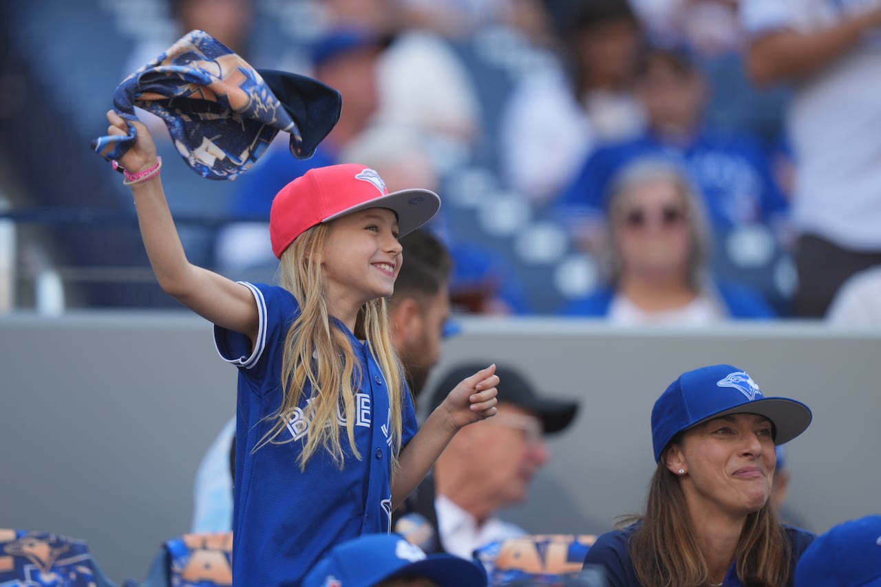 A young sports fan waves a towel.
