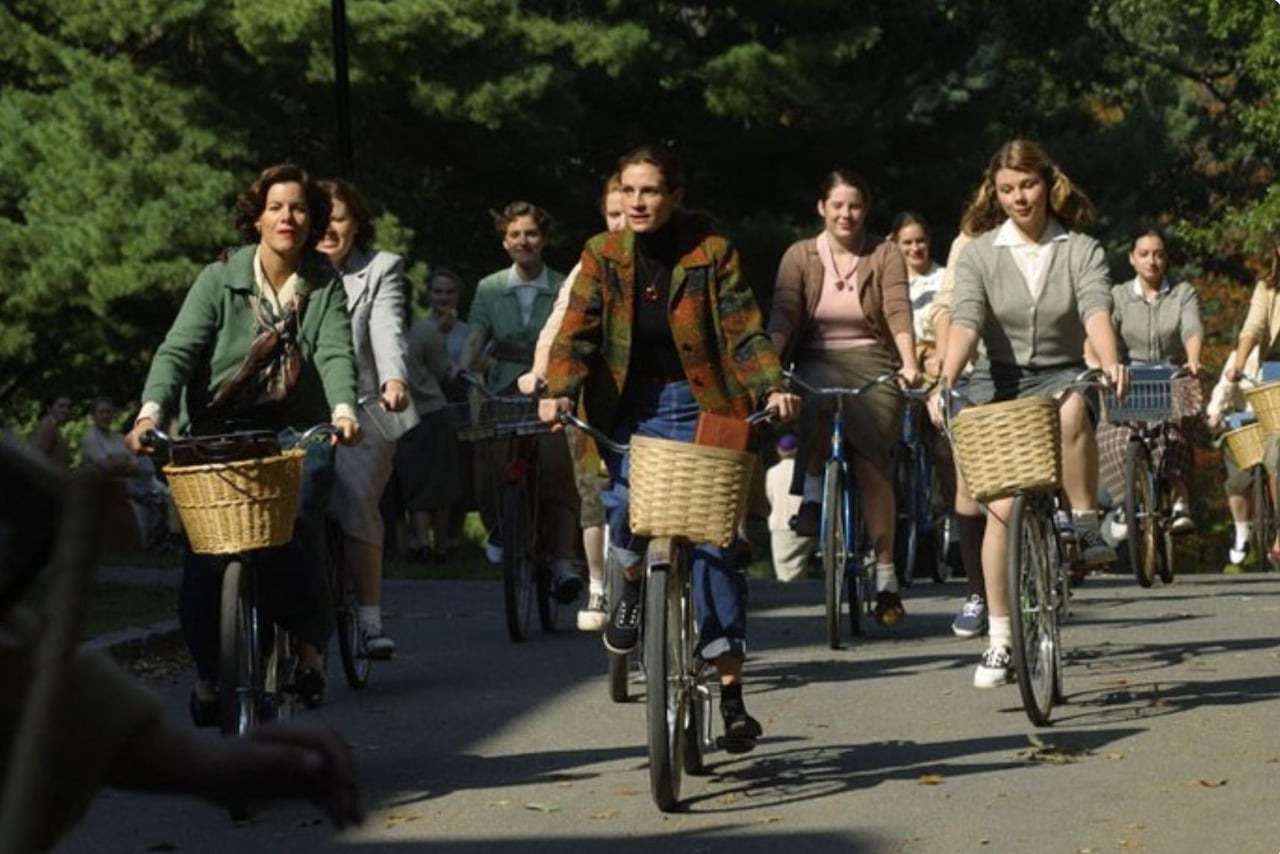 A group of women biking through a park. 