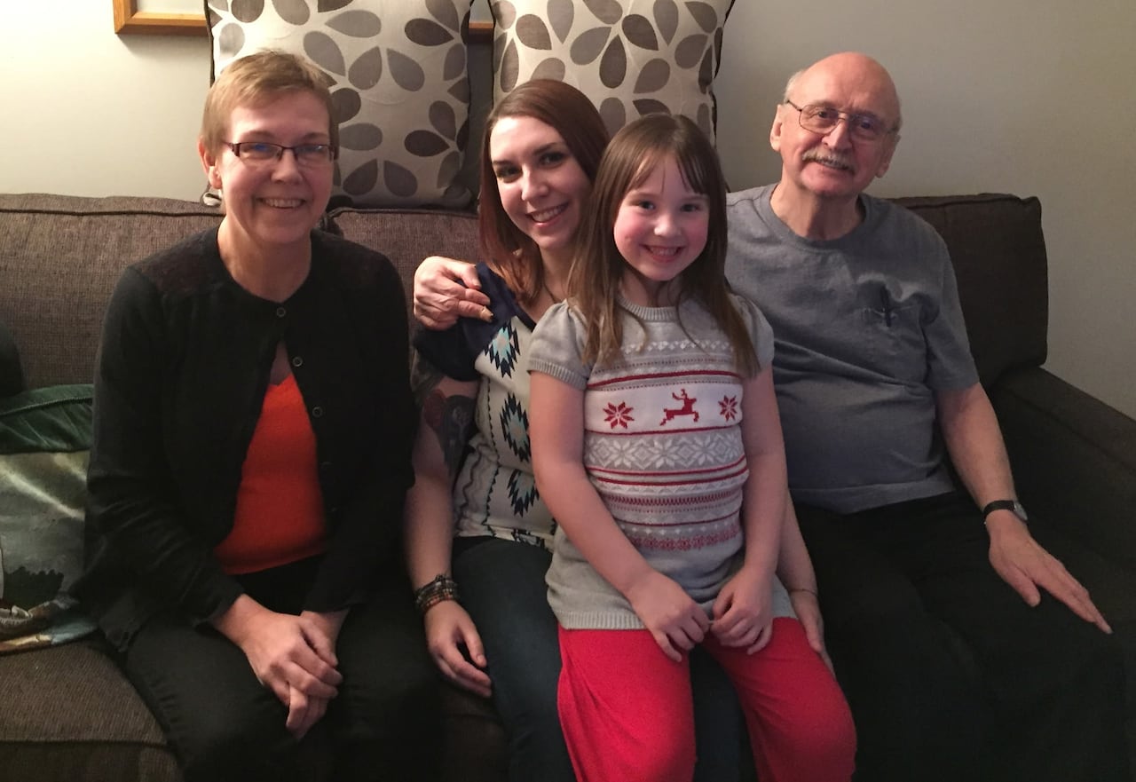 Three adults and a girl sitting together on a sofa