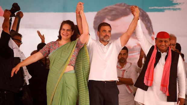 Leaders of India's main opposition Congress party Priyanka Gandhi Vadra, Rahul Gandhi and Akhilesh Yadav, chief of the regional Samajwadi Party, join their hands together during an election campaign rally in Raebareli in the state of Uttar Pradesh, India, May 17, 2024. Three people hold hands in the air and smile.