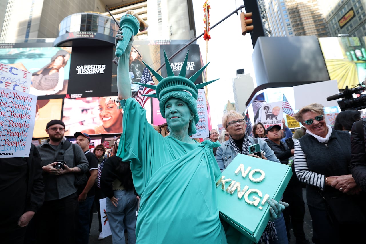 A person dressed in a Statue of Liberty costume marches in a rally.