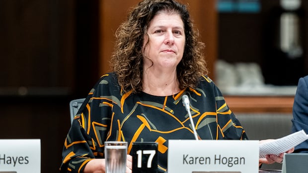 Auditor General of Canada Karen Hogan waits to appear before the Standing Committee on Government Operations and Estimates (OGGO) in West Block on Parliament Hill in Ottawa on Sept. 23, 2025.  A woman sits at a desk before a microphone preparing to testify before legislators.