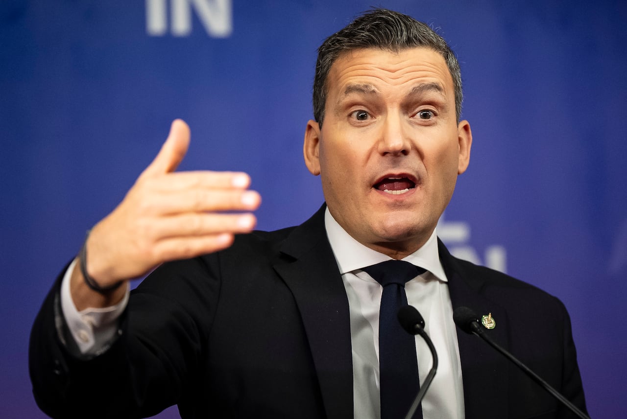 Vīrietis, kurš valkā melnu uzvalku, valkājot zilu kaklasaiti