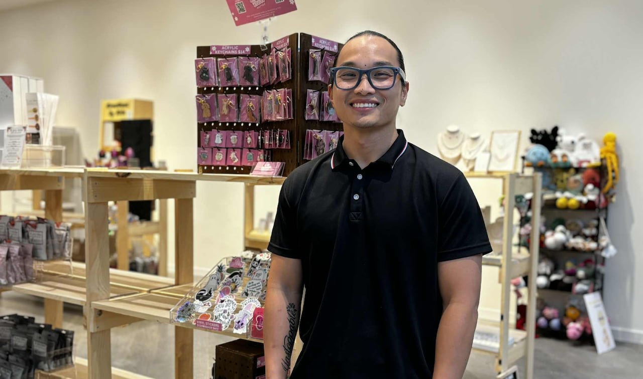 Un hombre sonríe a la cámara dentro de una tienda