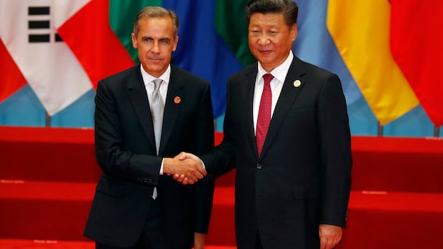 The Bank of England's governor Mark Carney, left, shakes hands with Chinese President Xi Jinping before a group photo session for the G-20 Summit in Hangzhou in eastern China's Zhejiang province, Sunday, Sept. 4, 2016. Two men in suits shaking hands.