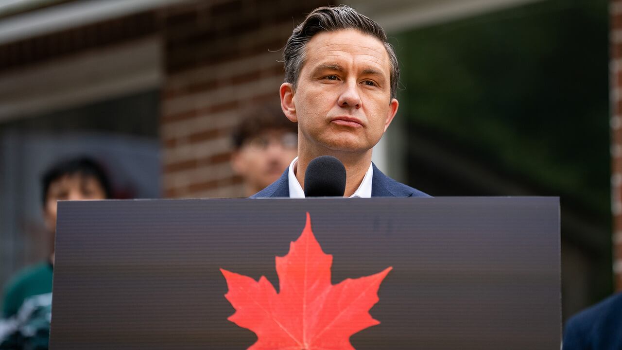 Man in suit stands in front of lecturn