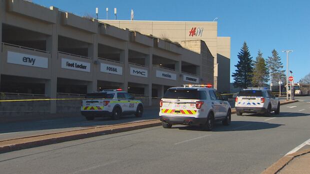 police vehicles parked outside a concrete parkade on a sunny day