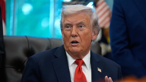 President Donald Trump answers questions from reporters during a Diwali celebration in the Oval Office at the White House, Tuesday, Oct. 21, 2025, in Washington. An older cleanshaven blonde-haired man is shown seated in closeup, speaking while wearing a suit and tie.