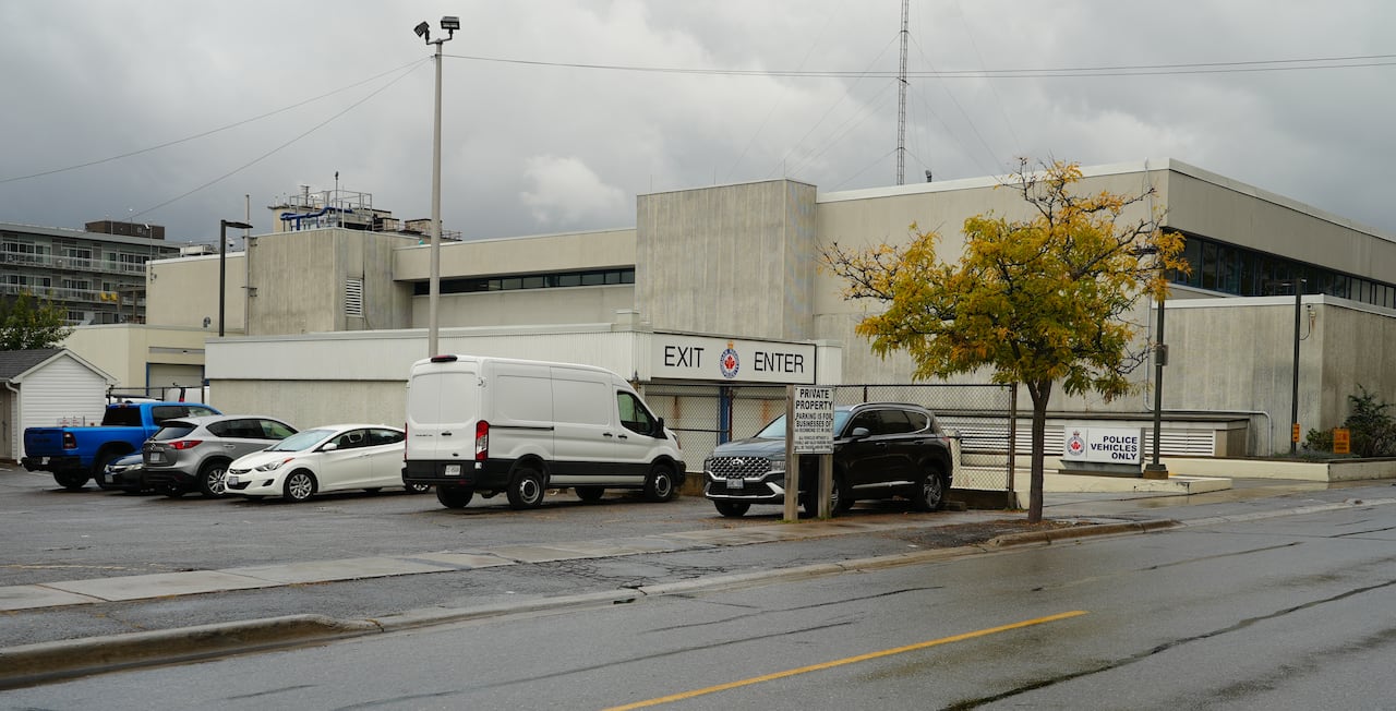 Private parking lot with vehicles beside police station.