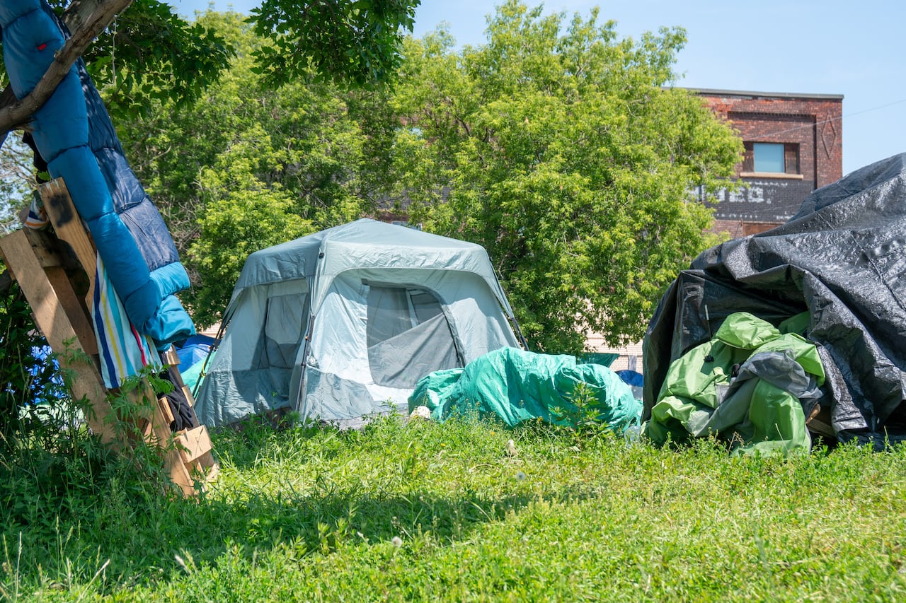 A clump   of tents is seen extracurricular  connected  greenish  grass.
