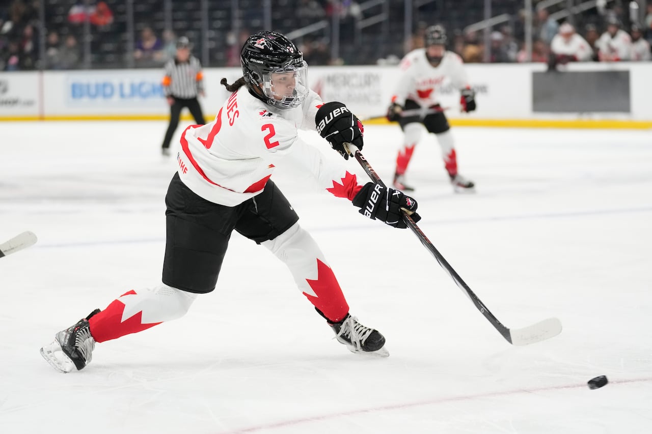 A hockey player shoots a puck.