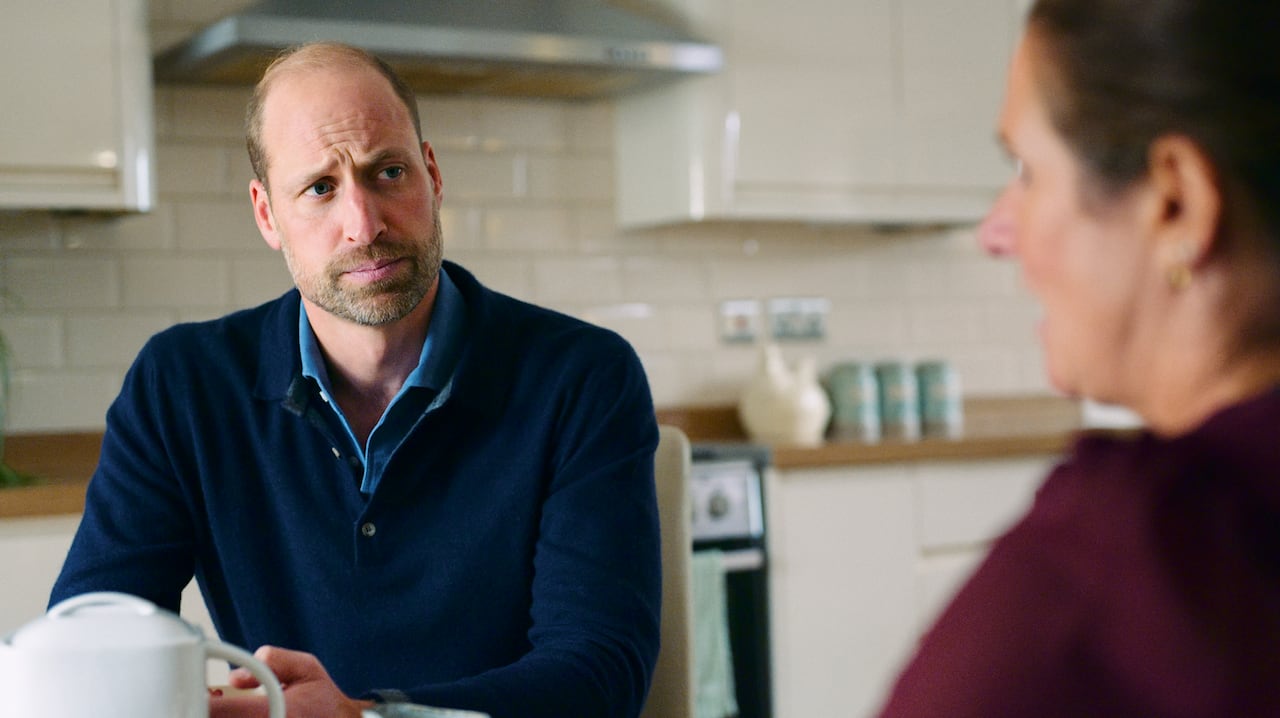Two people sit at a kitchen table.