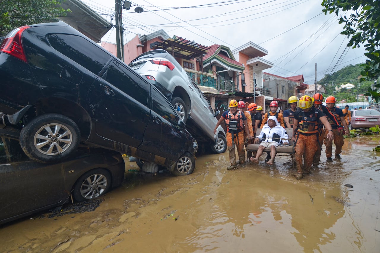 Several radical   successful  helmets assistance   assistance   an aged  idiosyncratic   implicit    a flooded street, arsenic  piled-up cars are shown nearby.