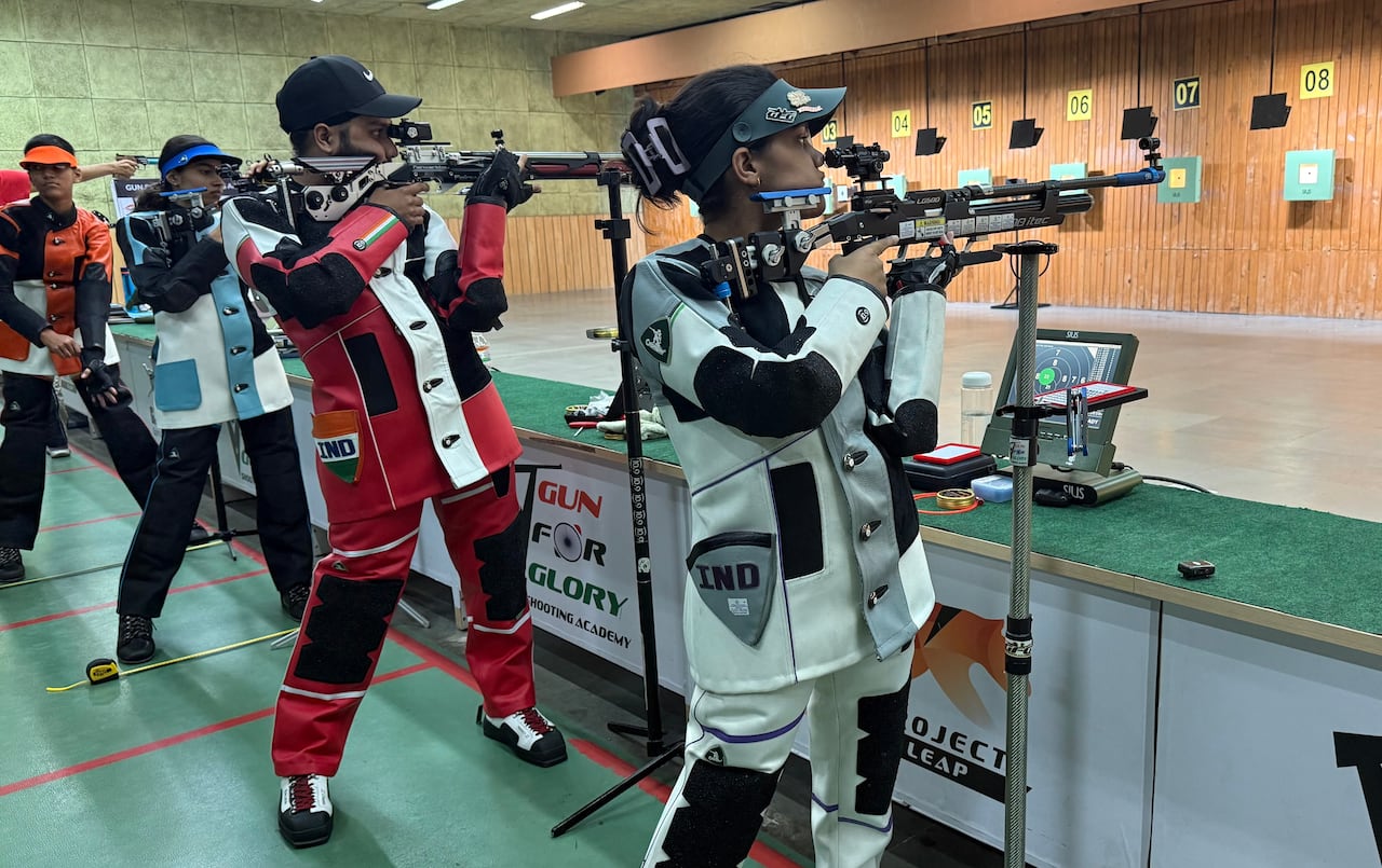 穿著不同顏色服裝的人們用大槍瞄準建築物內的目標。