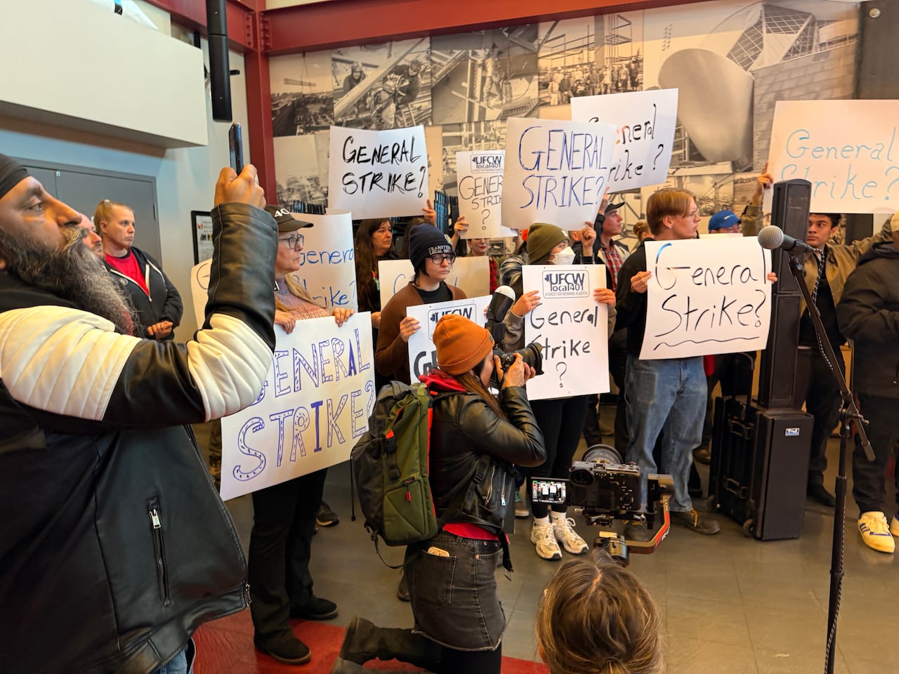 People hold posters that read "general strike," some with a question mark at the end of the phrase.