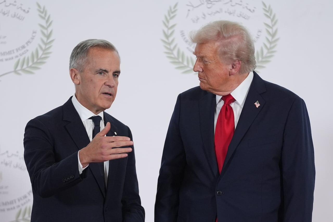 Two men in suits talk.