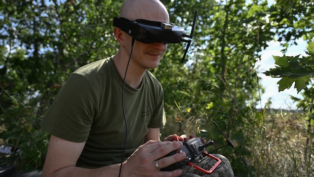 A Ukrainian serviceman from the 429th Separate Regiment of Unmanned Systems ACHILLES controls a FPV drone during a training flight in an undisclosed location, in eastern Ukraine on August 16, 2025, amid the Russian invasion of Ukraine. Ukrainian drone pilots are using a new score-based purchasing system that allows them to acquire points for kills, which they can cash in and replinish their stocks of drones. The market called Brave 1 is run by Ukraine's digitisation ministry, and has been dubbed by its creators as the world's first military Amazon, because it let's brigades choose the weapons they want and leave reviews. The platform's head says it promotes "healthy competition" not only between Ukrainian army drone units but also been producers to make the best weapons. (Photo by Genya SAVILOV / AFP) (Photo by GENYA SAVILOV/AFP via Getty Images) A man in military uniform uses a drone system, wearing a headset