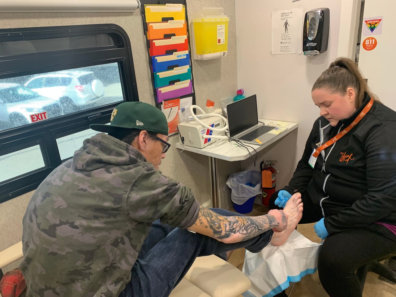 A man points to his big toe while a woman points to it.