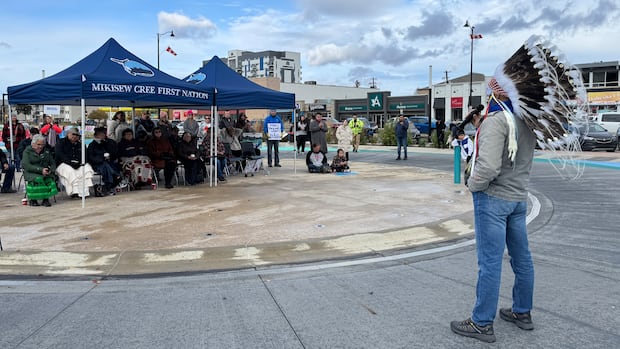 Chief Billy-Joe Tuccaro speaks at a gathering in downtown Fort McMurray in October 2025 to oppose provincial proposals to release treated oilsands tailings water into the Athabasca River. A man is seen speaking to a crowd of people.