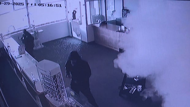 A grainy screen shot of security camera footage shows two masked figures surrounded by broken glass. Smoke is filling up the jewelry store they're attempting to rob.