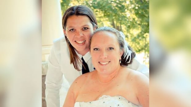 Brandy Cooney and Becky Hamber, left to right, are on trial in Ontario Superior Court in Milton, charged with first-degree murder of a 12-year-old boy.  Two women in wedding attire smile.