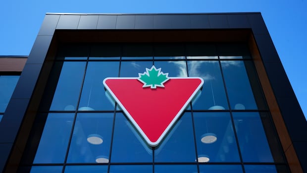 A Canadian Tire logo is displayed on a store in Ottawa on Friday, Aug. 11, 2023. A red triangle affixed with a green maple leaf is displayed on the exterior of a building.