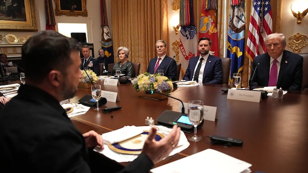 Man seated across from a row of men in suits