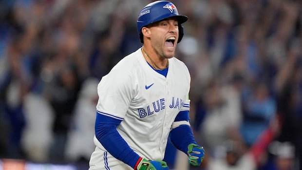 A baseball player laughs and clenches his fists.