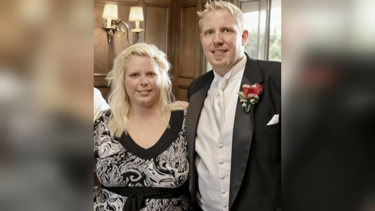Two young people stand side by side smiling.