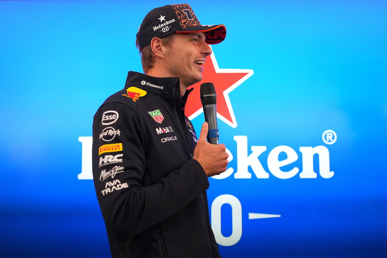 Side profile of Max Verstappen speaking into a microphone, with the Heineken