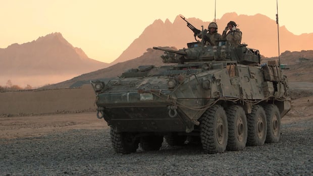 A military vehicle is seen operated in the desert.