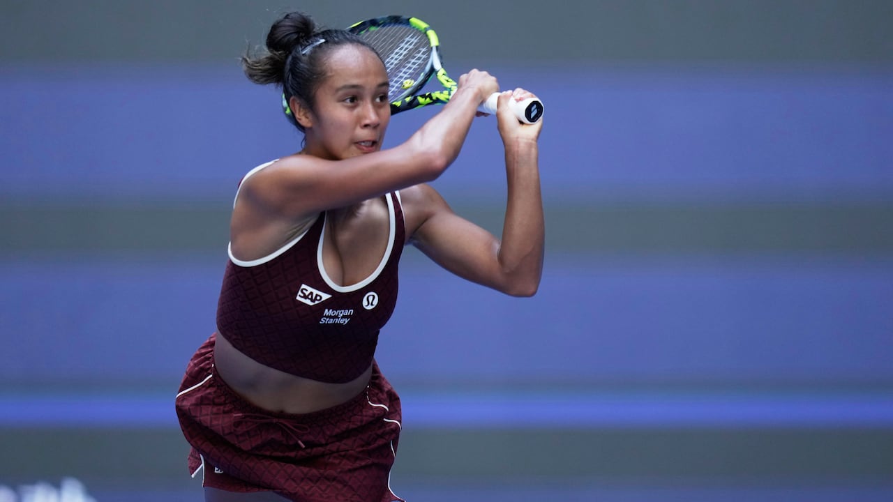 A pistillate tennis subordinate holds some hands connected the racket aft returning a shot.