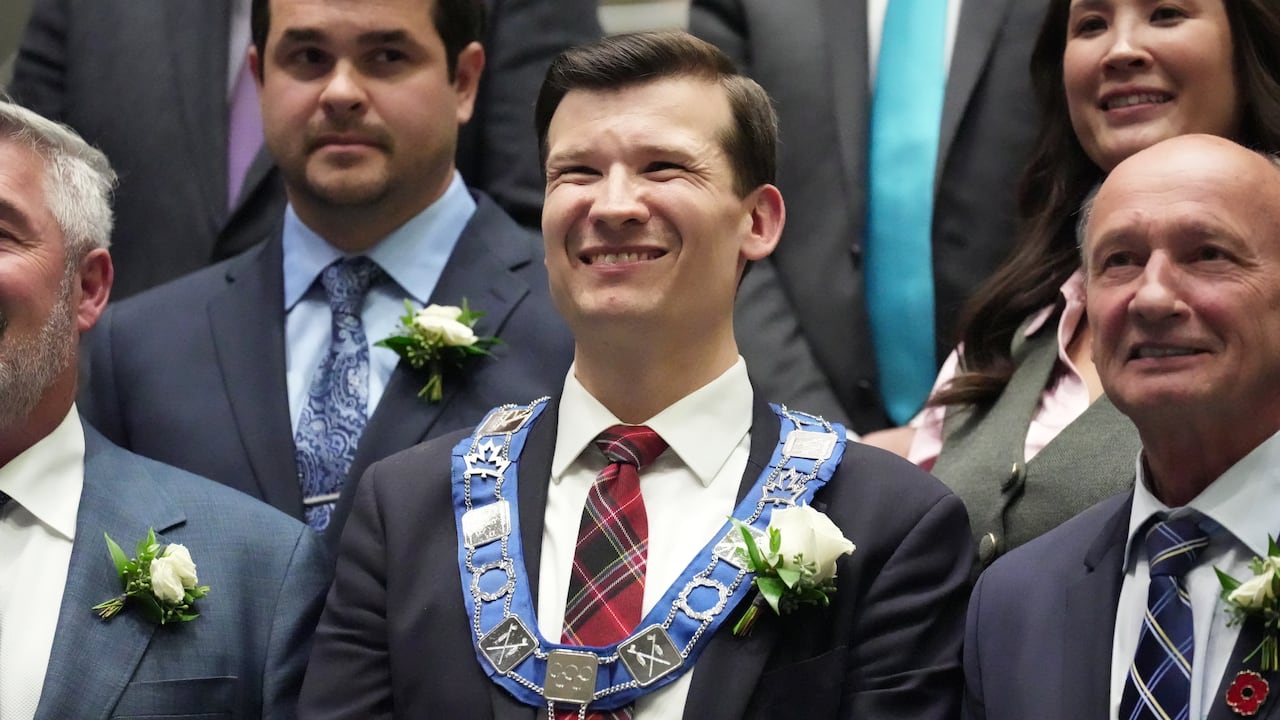 Person in mayor's chain, flanked by other people