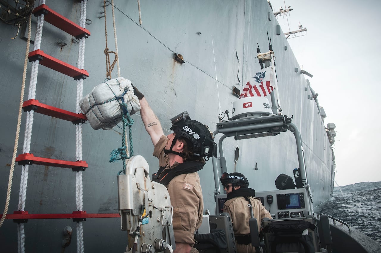 A man giving a square package up.