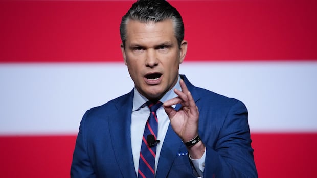 Secretary of Defense Pete Hegseth speaks to senior military leaders at Marine Corps Base Quantico, Tuesday, Sept. 30, 2025 in Quantico, Va. Man in blue suit gestures as he speaks