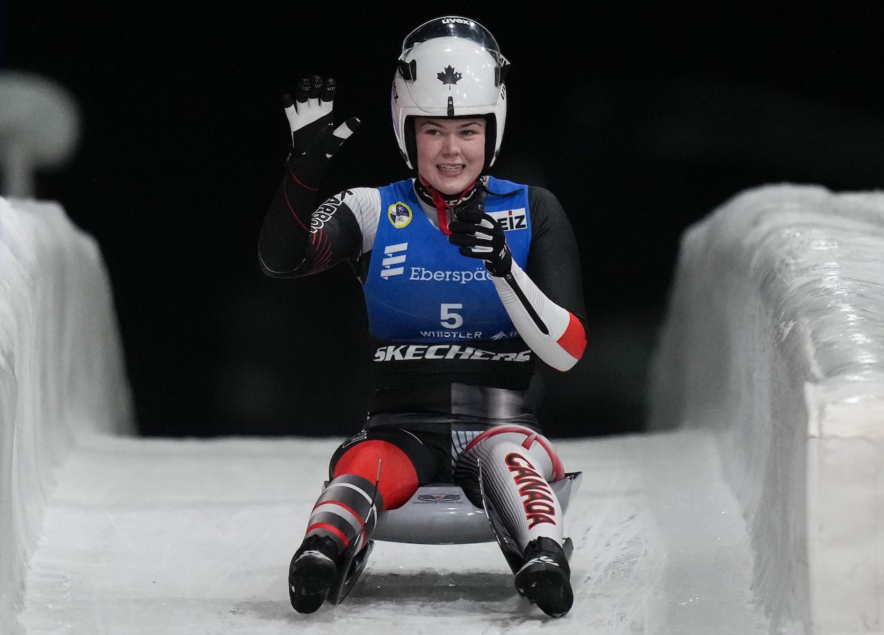 Canadian pistillate  luger waves portion    sitting connected  her sled connected  the track.