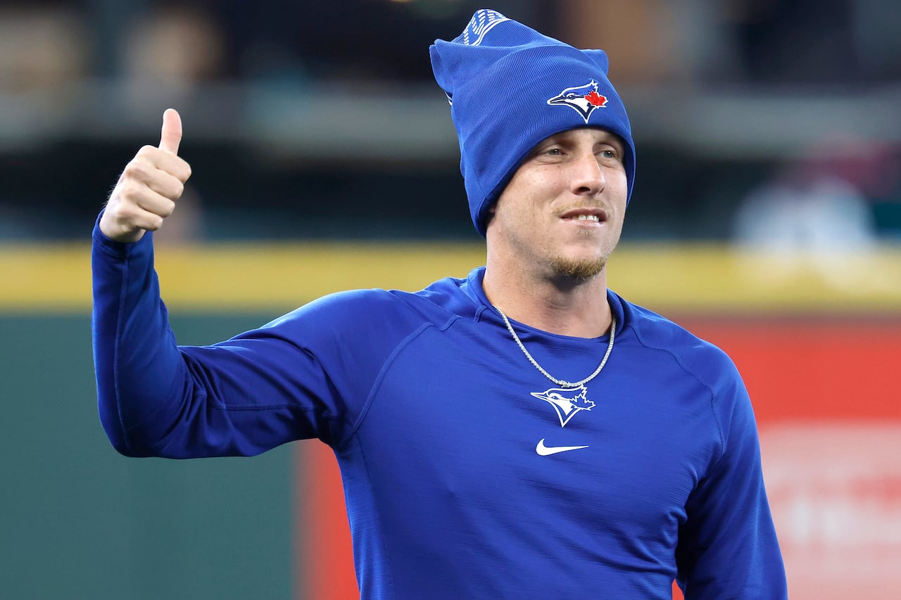 A baseball player, who is wearing a toque, gives a thumbs up