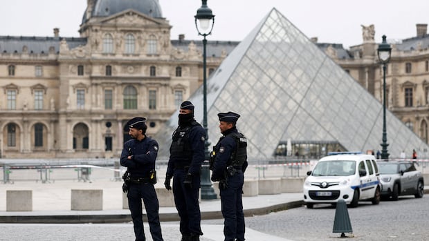 People in uniform stand outside a museum building.