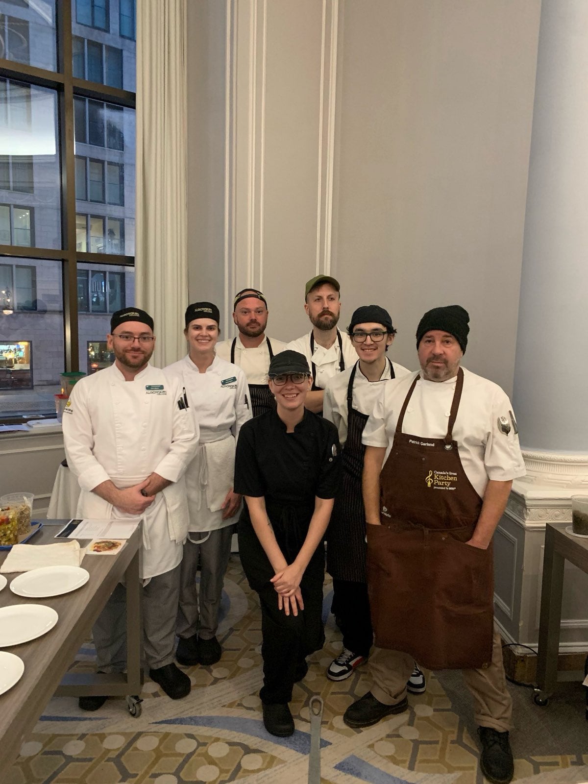 Group photo of seven chefs in a restaurant kitchen.