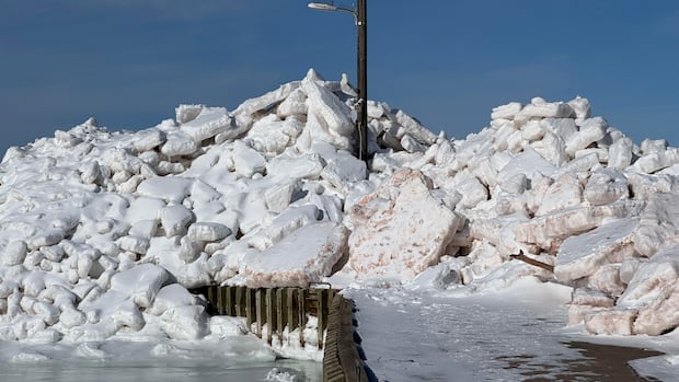Piles of ice has formed a wall in the wharf in Cape Egmont. Piles of ice have washed onto the wharf in Cape Egmont.