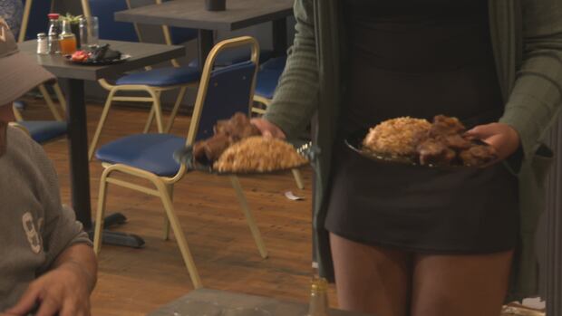Restaurant diners saved some money thanks to the federal HST holiday. A waiter brings two plates to a table.